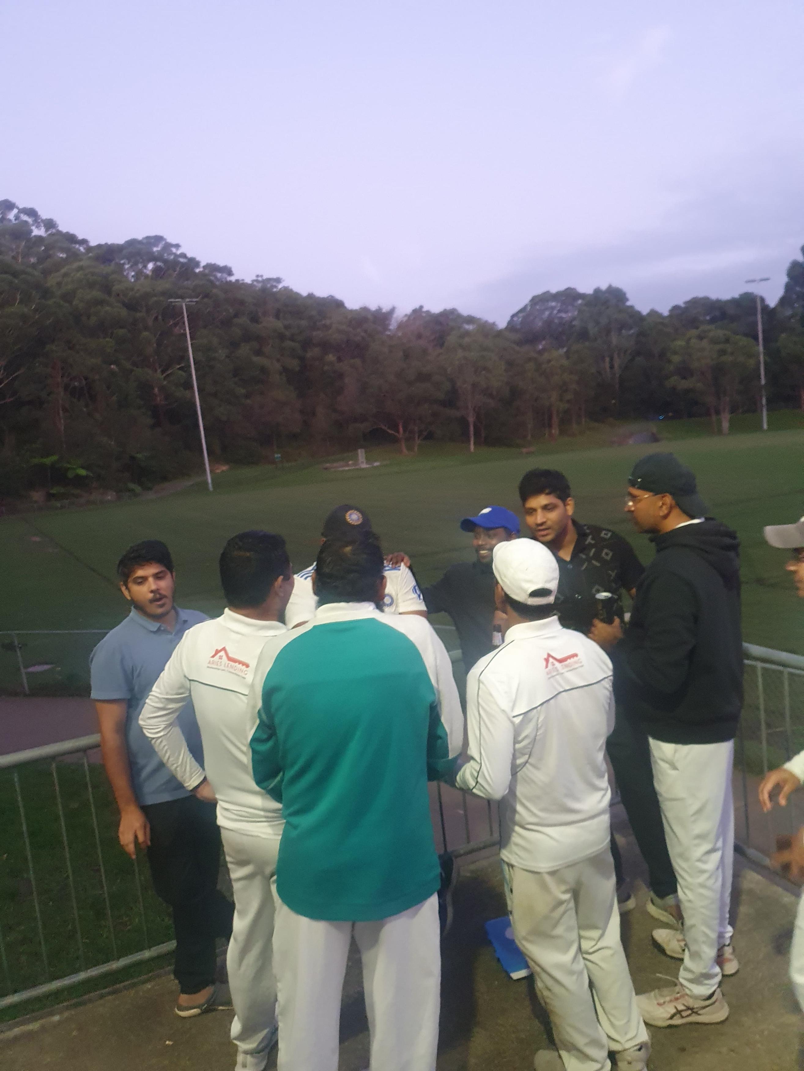 Hornsby Tigers players in a team huddle by the boundary